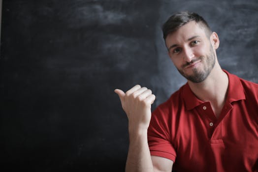 Young man in red polo shirt gesturing, smiling, and looking confident.